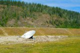 Vesmírný satelit zanořený do země při břehu Yukonu - jde jen o model, který sem umístil jakýsi umělec.