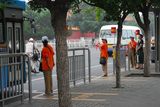 30.7. 2008 - Peking. Dobrovolní pomocníci v oranžových tričkách na zastávce autobusu.