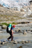 Peťulka přeskakuje po kamenech odtok ledovce Hardangerjøkulen.